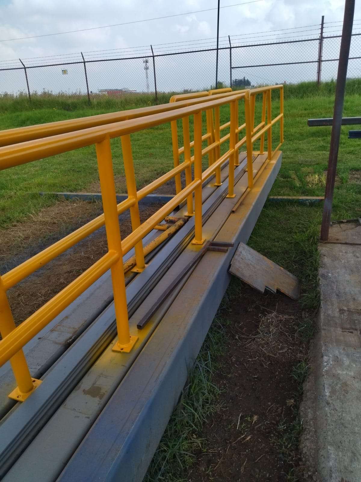 Barandal amarillo en instalación industrial