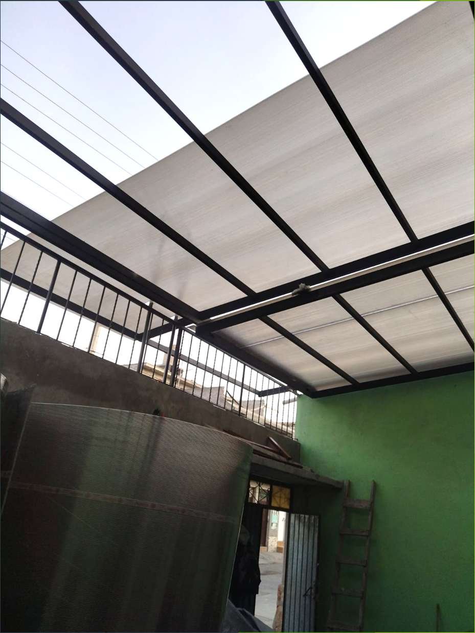 Cubierta translúcida con estructura metálica sobre patio